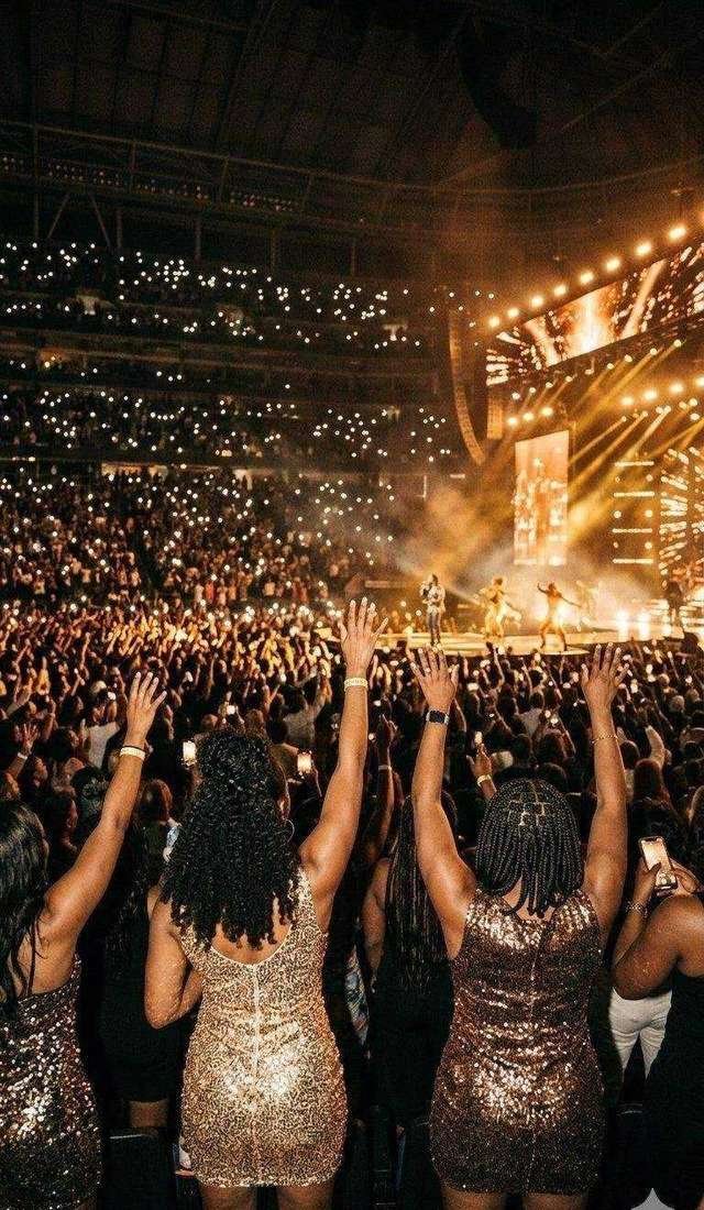 Black women at R&B concert hands raised